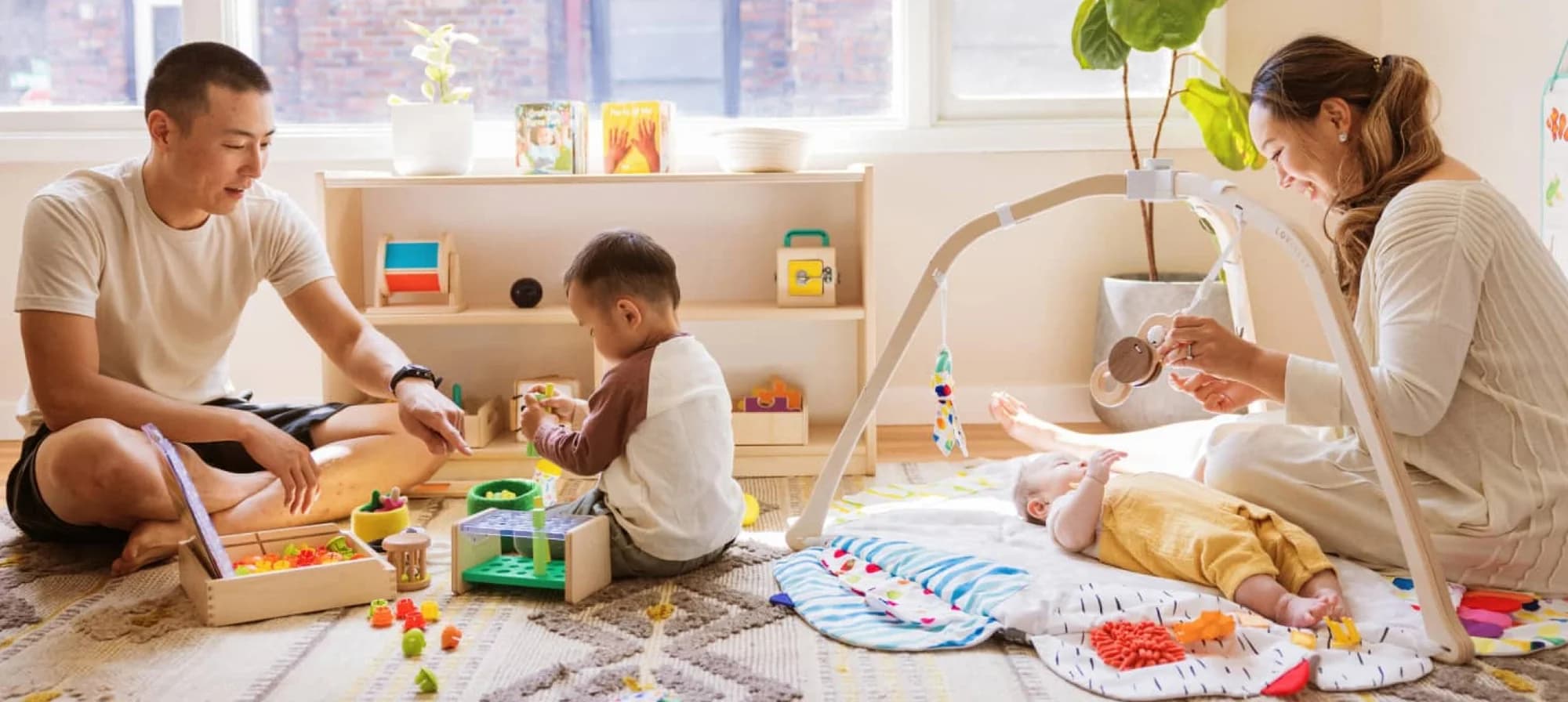 Family playing with toys from The Play Kits and The Play Gym by Lovevery